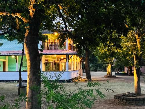 a house with a porch and a balcony on it at Funky Leopard Safari Lodge Bordering Yala National Park in Kataragama
