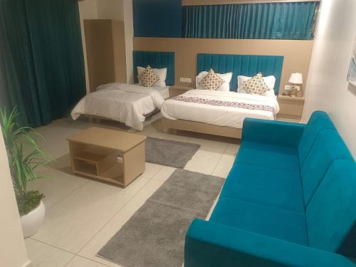 a living room with two beds and a couch at Hotel Royal Square in Gandhinagar