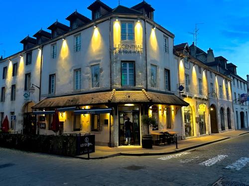 a large white building with a store in front of it at Le Central Boutique Hôtel in Beaune