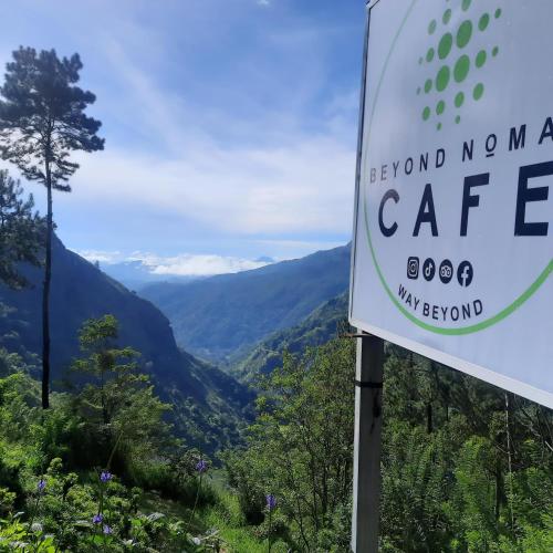 a sign for a cafe with mountains in the background at Beyond Nomad Luxury Hostel in Ella