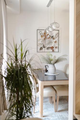 a dining room table with two potted plants at Fontana apartmani 1 FREE parking in Tuzla