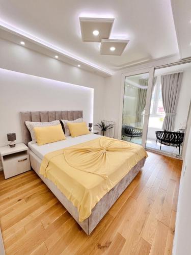 a bedroom with a large bed with yellow sheets at Fontana apartmani 1 FREE parking in Tuzla