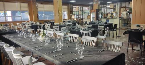 a long table in a library with white chairs and glasses at Hostal los Rosales in Almázcara