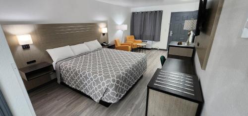 a small hotel room with a bed and a chair at Country Inn Banning in Banning