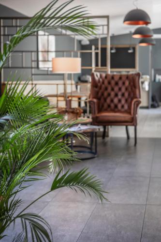 a living room with a couch and a chair at Charm Boutique Hotel in Satu Mare
