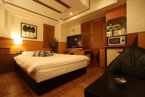 Habitación de hotel con cama y sofá en HOTEL Q, en Tokio