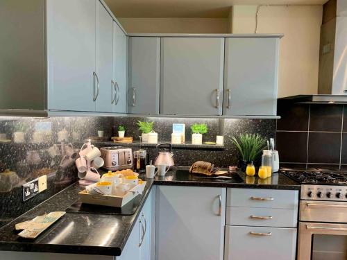 a kitchen with white cabinets and a counter top at Jack's House in Tywyn