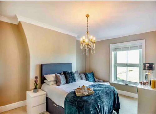 a bedroom with a bed and a chandelier at Jack's House in Tywyn