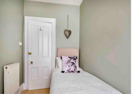 a small bedroom with a bed and a white door at Jack's House in Tywyn
