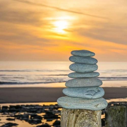 a stack of rocks on a post on the beach at Jack's House in Tywyn