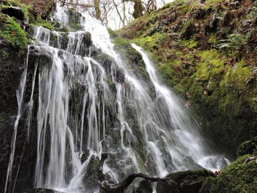 a waterfall on the side of a mountain at Jack's House in Tywyn