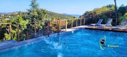 une personne dans une piscine avec une personne dans l'eau dans l'établissement O SOHNO 4 pers vue Mer Piscine, à Sainte Trinité