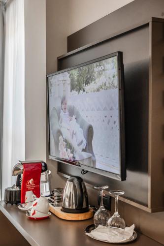 a television with a picture of a woman sitting in a chair at Charm Boutique Hotel in Satu Mare