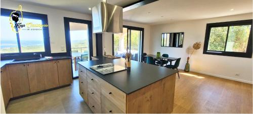 - une cuisine avec un îlot au milieu d'une pièce dans l'établissement O SOHNO 4 pers vue Mer Piscine, à Sainte Trinité