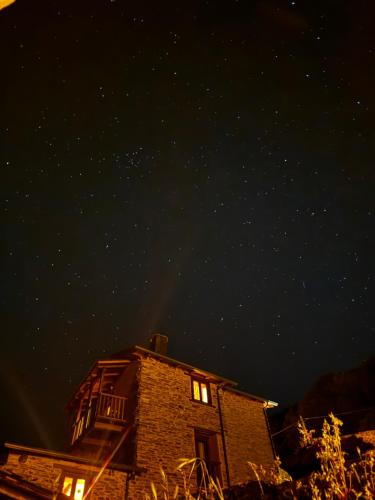 a night view of a building with lights on at Lar da cima in Folgoso