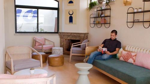a man sitting on a couch in a living room at WOT Sintra Ocean in Sintra