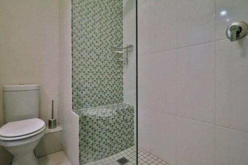 ein Badezimmer mit Toilette und Glasdusche in der Unterkunft Stunning Resort Living, Unit 37 in Summerstrand