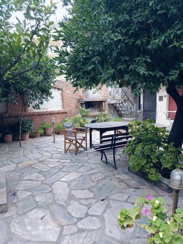 a patio with a picnic table and a bench at Anesis Hotel in Loutra Edipsou