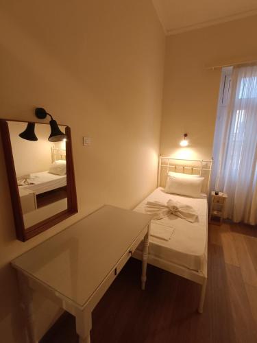 a bedroom with a table and a mirror and a bed at Anesis Hotel in Loutra Edipsou