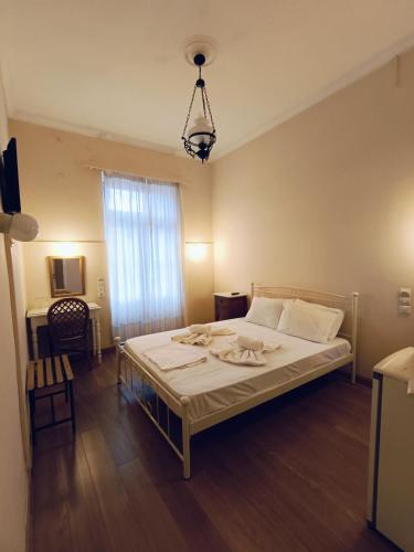a bedroom with a bed and a chandelier at Anesis Hotel in Loutra Edipsou