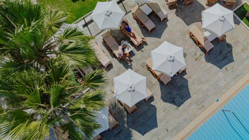 an overhead view of a pool with tables and umbrellas at Golden Coast Beach Hotel in Protaras