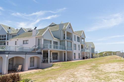 a large white house with a lawn in front of it at Luxury On The Beach in Summerstrand