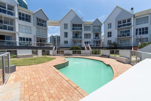 a swimming pool in front of some apartment buildings at Luxury On The Beach in Summerstrand
