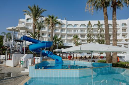 a pool with a slide in front of a hotel at Golden Coast Beach Hotel in Protaras