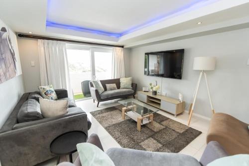 a living room with two couches and a tv at The Pearls 2nd Floor Luxury Apartment in Port Elizabeth