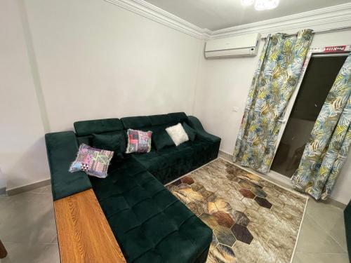 a green couch in a living room with curtains at الساحل الشمالي in El Alamein