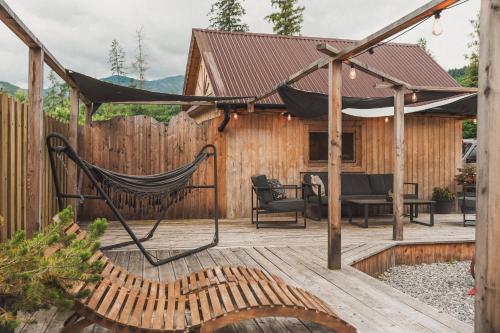 a hammock on a deck with a house at Apartamenty Truchanówka przy Dolinie Chochołowskiej in Witów