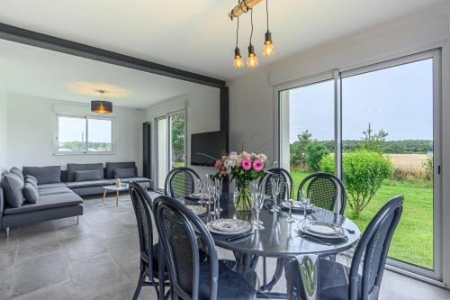 a dining room with a table and chairs at L'Envolée de Charme - Maison à 10m de Vannes in Theix
