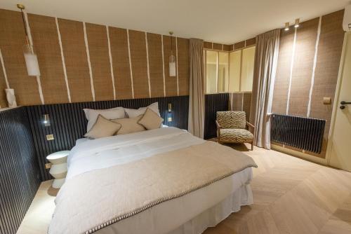 une chambre avec un grand lit blanc et une chaise dans l'établissement Basfroi Cosy Apartment 2, à Paris