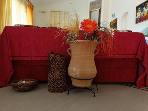 a vase with a flower in front of a couch at Forest view apartment in Zigós