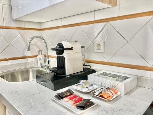 un bancone della cucina con frullatore e piatto di cibo di APARTAMENTOS NURIA 19 a Granada