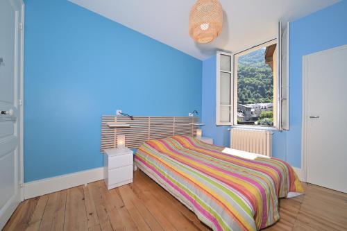 une chambre bleue avec un lit et une fenêtre dans l'établissement Le Clos du Casino, à Luchon