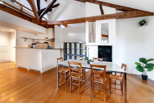 une cuisine et une salle à manger avec une table et des chaises dans l'établissement Appartements de charme Paris Expo Porte de Versailles, à Malakoff