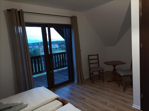a bedroom with a balcony with a bed and a chair at Sosnówka in Krutyń