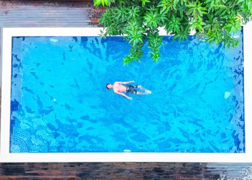 a man swimming in a swimming pool in the water at Bliss & Beats Hostel in Phnom Penh