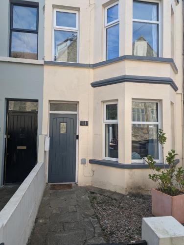 a house with a blue door and windows at Prospect House - Elegant 4-Bed Family Escape Near Ward Park & Marina in Bangor
