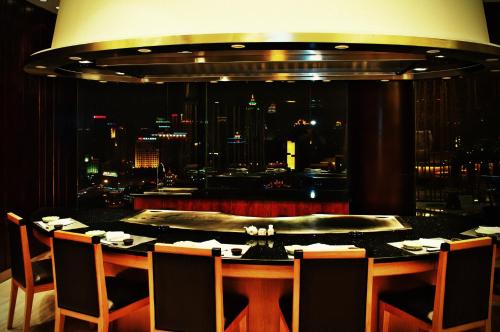 a restaurant with a table with a view of a city at Hotel Nikko Wuxi in Wuxi