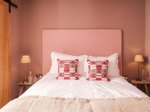 ein Schlafzimmer mit einem großen weißen Bett mit zwei Kissen in der Unterkunft The Old Winery Cottage No2 in Shepton Mallet