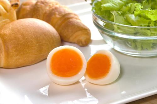 a plate with eggs and lettuce and a bowl of bread at WASHINGTON R&B Hotel Ueno Hirokoji in Tokyo