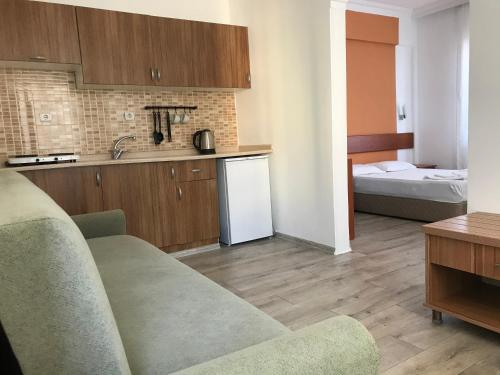 a kitchen with a couch and a room with a bed at Melissa Garden Apart Hotel in Side