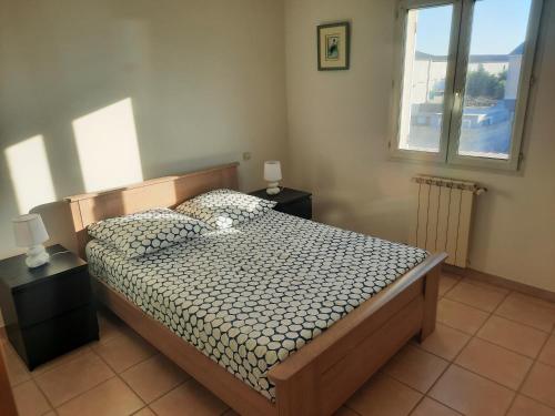 une chambre avec un lit avec deux tables de nuit et une fenêtre dans l'établissement Maison l isle sur la sorgue, à LʼIsle-sur-la-Sorgue