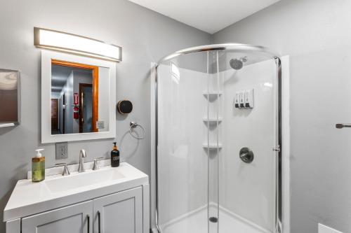 a bathroom with a shower and a sink and a mirror at Shaligohomes On 16th Ave in Anchorage