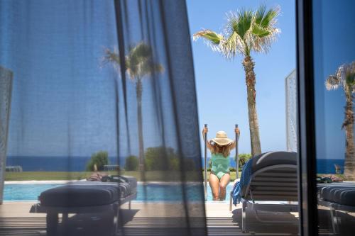 a woman jumping into a swimming pool at a resort at Iberostar Selection Creta Marine in Panormos Rethymno