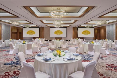 a ballroom with white tables and white chairs at Mandarin Oriental, Jakarta in Jakarta
