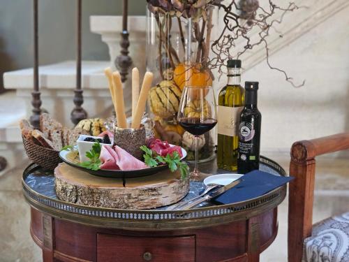 a table with wine glasses and a bowl of food at La Divine Comédie-Suites Deluxe in Avignon