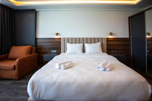 a bedroom with a large bed with two slippers on it at Batumi View Luxury in Batumi
